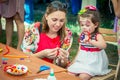 Mother and daughter participating at art and craft outdoor workshop